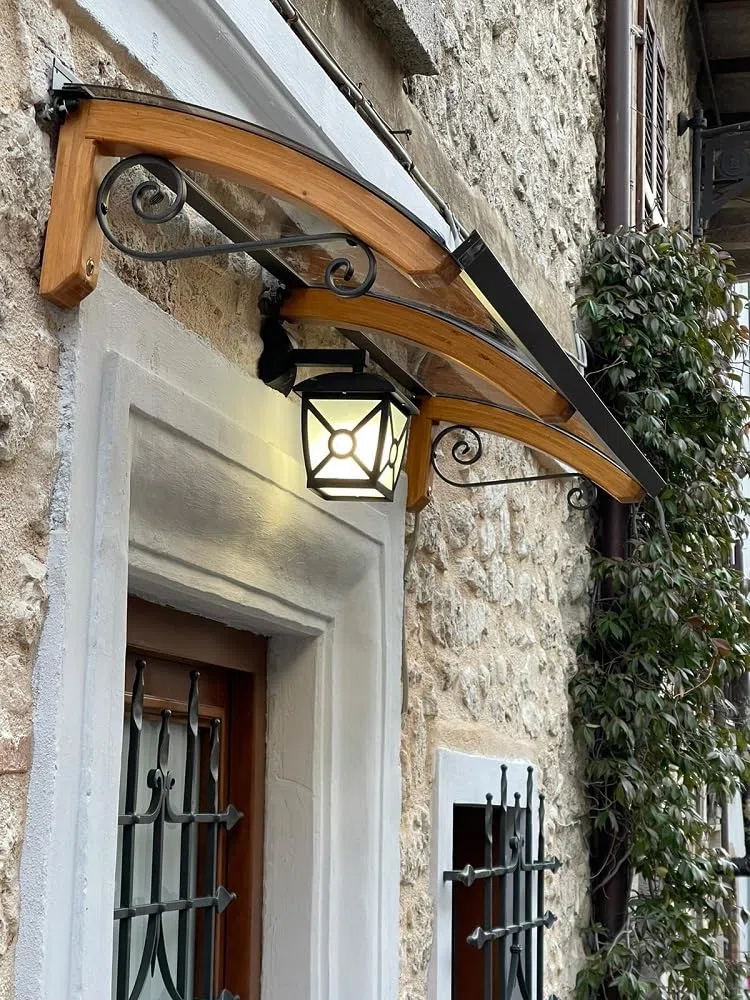 Pensilina da esterno in legno lamellare, copertura in policarbonato compatto Bronzato, Modello Legno Riccio, dimensioni 60 X 150 cm, colore legno e ferro Bianco